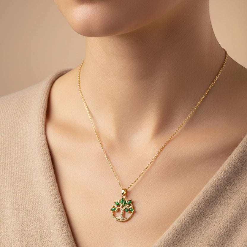 SVORA gold Tree of Life pendant necklace with emerald marquise CZ leaves and white CZ accents on a thin gold chain.