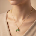 SVORA gold Tree of Life pendant necklace with emerald marquise CZ leaves and white CZ accents on a thin gold chain.