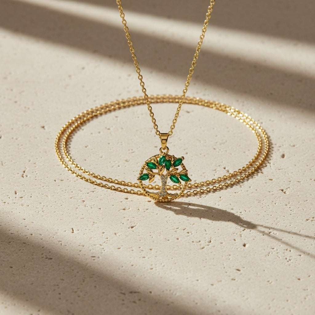 SVORA gold plated stainless steel necklace with emerald marquise CZ leaves and white CZ accents forming a Tree of Life pendant.