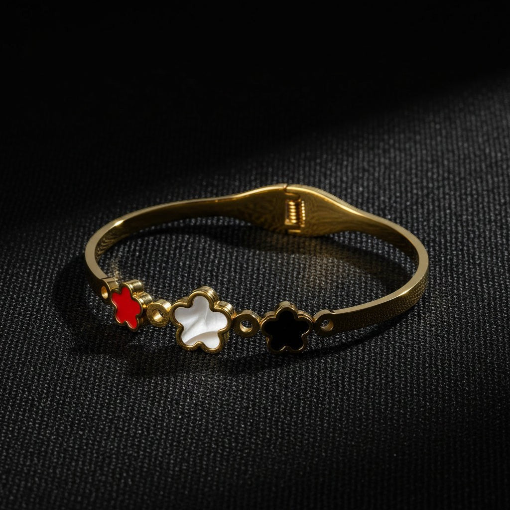 SVORA gold plated stainless steel bracelet with three five-petal blooms in red, white, and black.