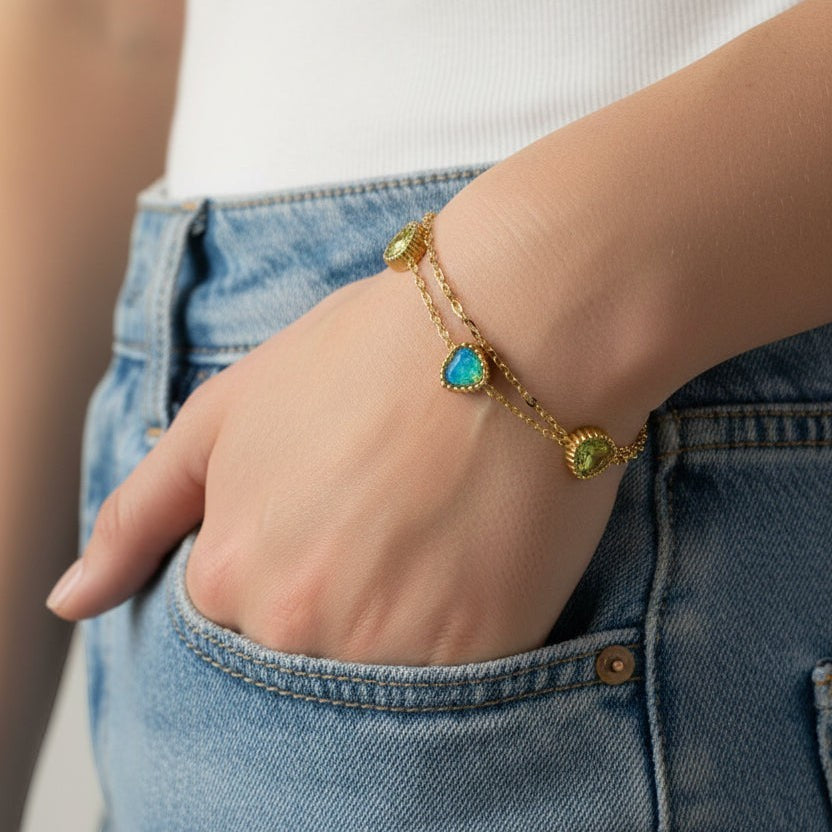 SVORA gold layered bracelet with three emerald-cut green stones and a central blue stone. Adjustable, lobster clasp.
