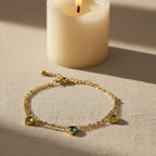 SVORA Triple Emerald Layered Chain Bracelet with gold-plated stainless steel and green cubic zirconia stones.