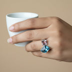 SVORA Toi et Moi Twilight Sapphire Ring with blue abstract-cut and pinkish-purple emerald-cut stones on ribbed stainless steel band.