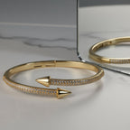 SVORA gold plated stainless steel bypass bracelet with two arrowheads and pavé cubic zirconia stones