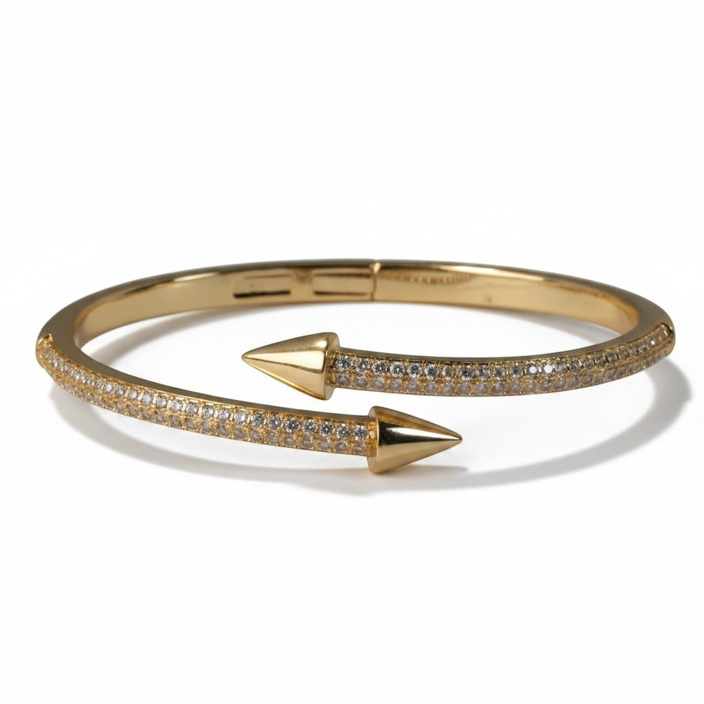 SVORA gold plated stainless steel bypass bracelet with pave cubic zirconia and arrowheads.