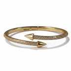 SVORA gold plated stainless steel bypass bracelet with pave cubic zirconia and arrowheads.