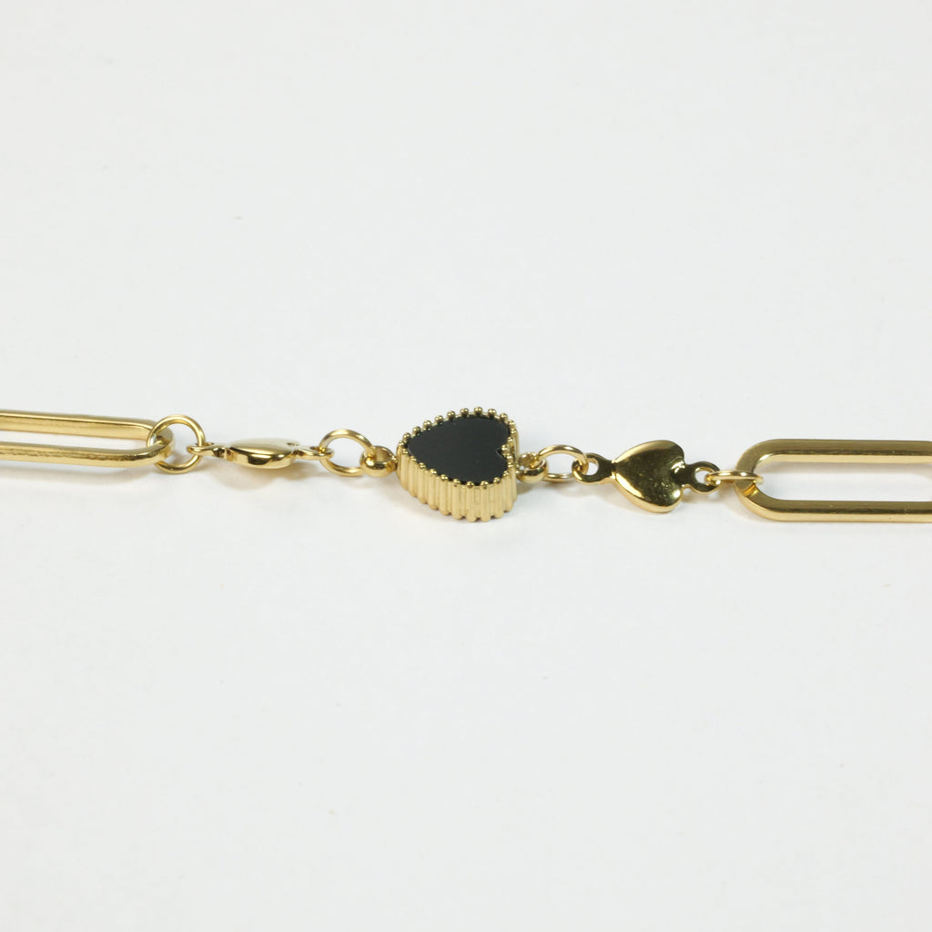 SVORA gold twisted rope chain bracelet with a black heart charm and two smaller gold heart charms.