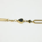 SVORA gold twisted rope chain bracelet with a black heart charm and two smaller gold heart charms.