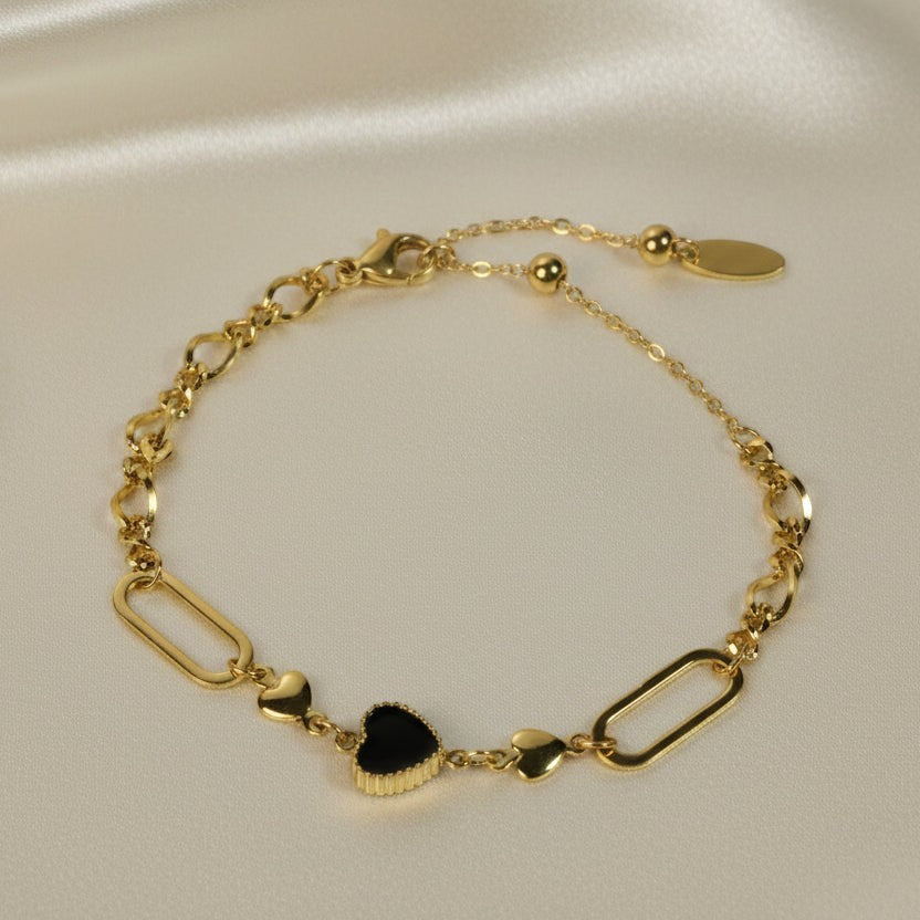 SVORA gold twisted rope chain bracelet with a black heart charm and oval links. Adjustable.