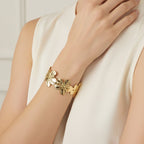 SVORA gold cuff bracelet with five sculpted floral blooms, diamond-cut finish, 18K gold plated stainless steel.