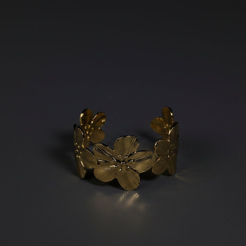 SVORA gold cuff bracelet with five sculpted floral blooms, diamond-cut finish, 18K gold plated stainless steel.
