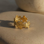 SVORA gold cuff bracelet with five sculpted floral blooms, diamond-cut finish, 18K gold plated stainless steel.