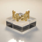 SVORA Wildbloom Cuff Bracelet in gold-plated stainless steel, featuring five sculpted flower blooms with diamond-cut petals. Adjustable design.