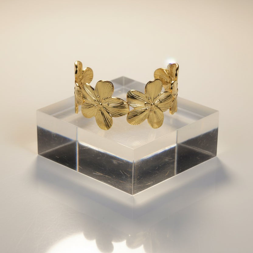 SVORA Wildbloom Cuff Bracelet in gold-plated stainless steel, featuring five sculpted flower blooms with diamond-cut petals. Adjustable design.