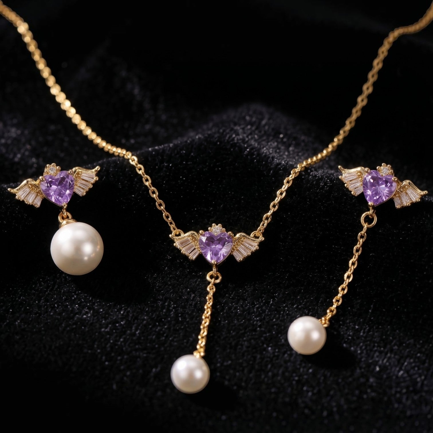 SVORA gold-tone necklace and asymmetric earrings with purple winged hearts and pearl drops.