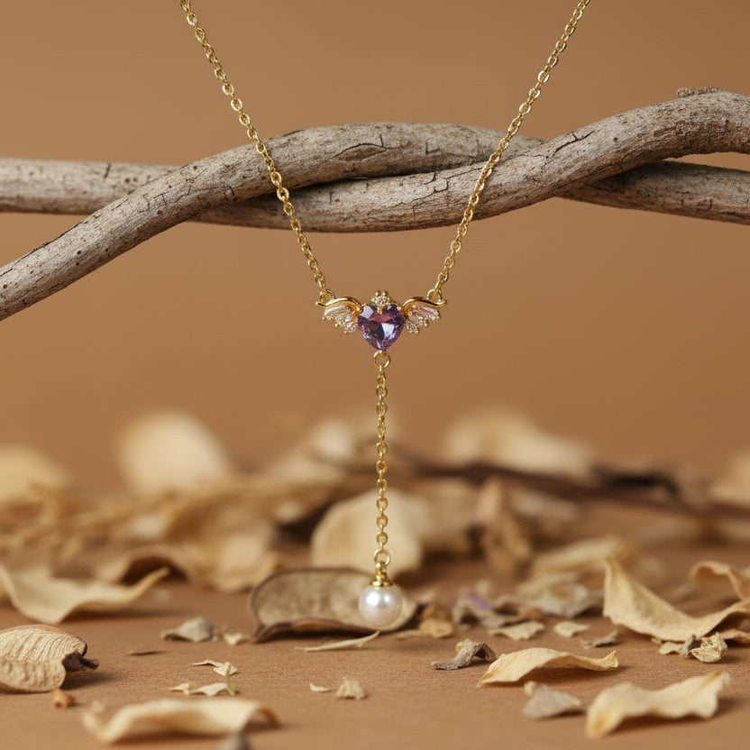 SVORA gold-tone necklace with a winged purple heart pendant and pearl drop.